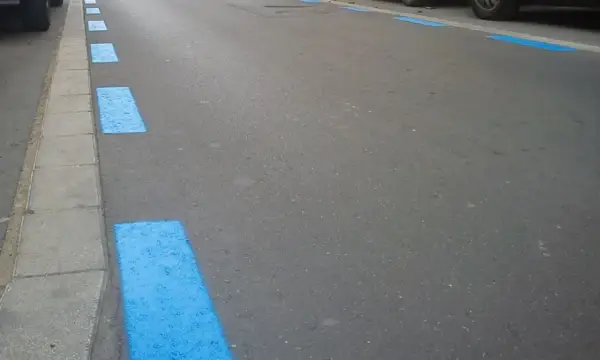 Marcas azules en el asfalto indican zona de aparcamiento regulado. Si no pagaste, así podrías saber si te han multado en zona azul.